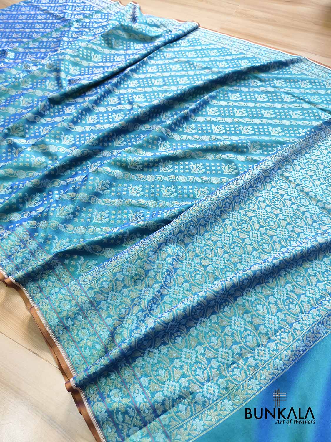 Turquoise blue Ektara Banarasi Jamdani silk saree with intricate floral weaving, elegant border and matching blouse for festive occasions.