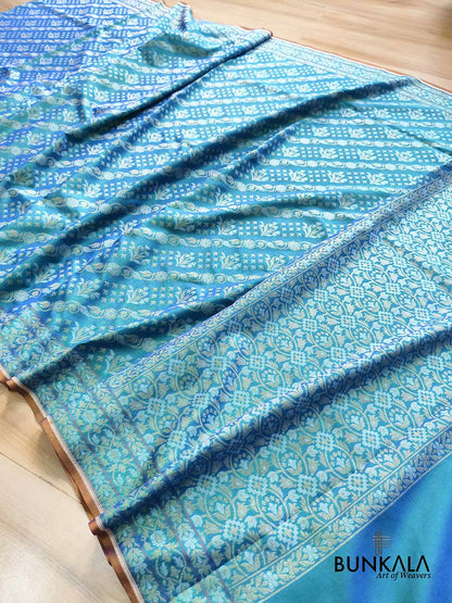 Turquoise blue Ektara Banarasi Jamdani silk saree with intricate floral weaving, elegant border and matching blouse for festive occasions.
