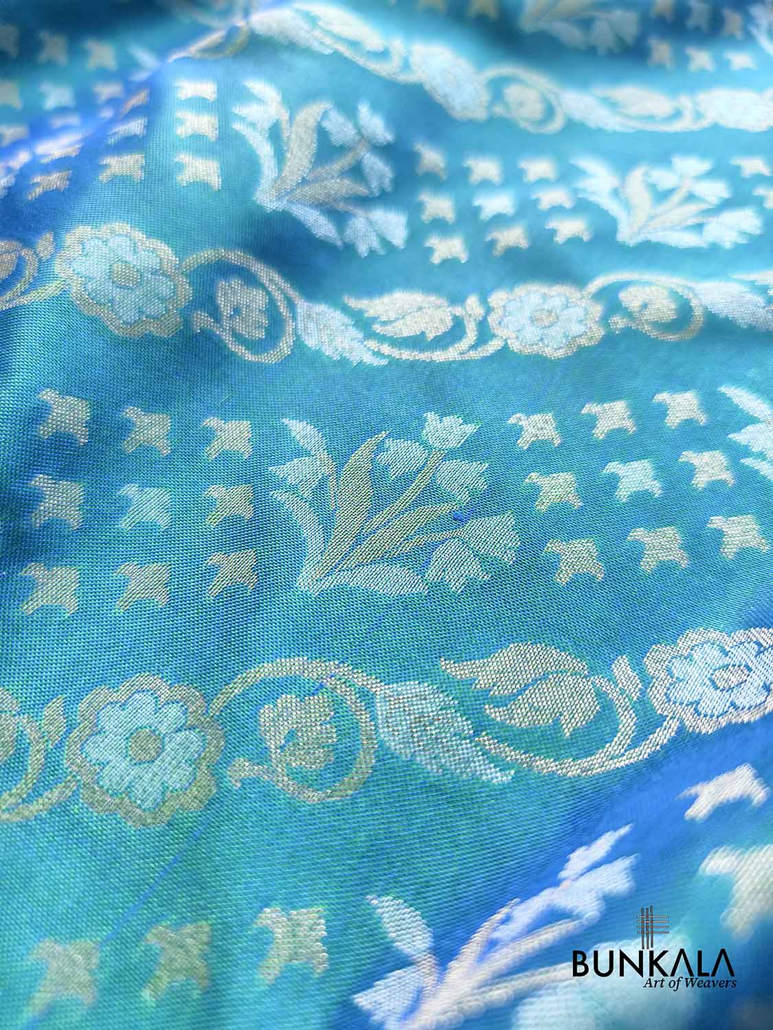 Turquoise blue Ektara Banarasi Jamdani silk saree with intricate floral weaving, elegant border and matching blouse for festive occasions.